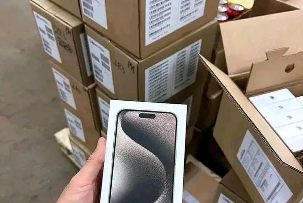 Pilha de caixas de fones sem fio e de uma caixa de som lacradas sobre uma superfície clara